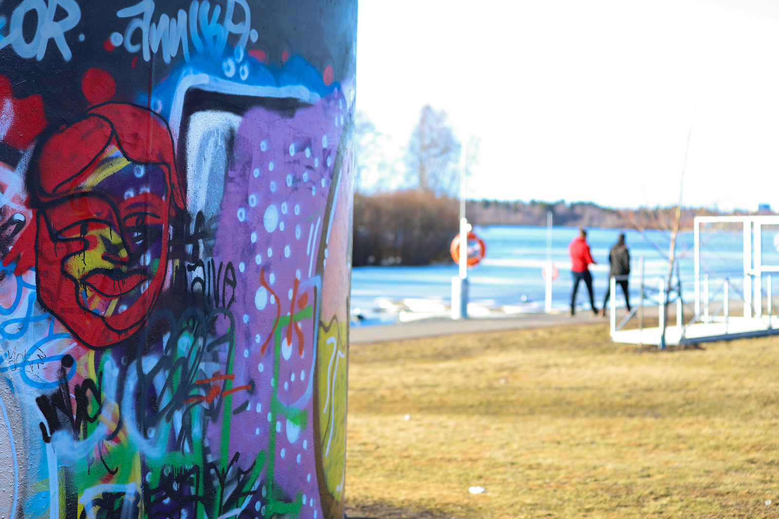 Ulkoilijoita graffitiseinän lähistöllä Hollihaan puistossa