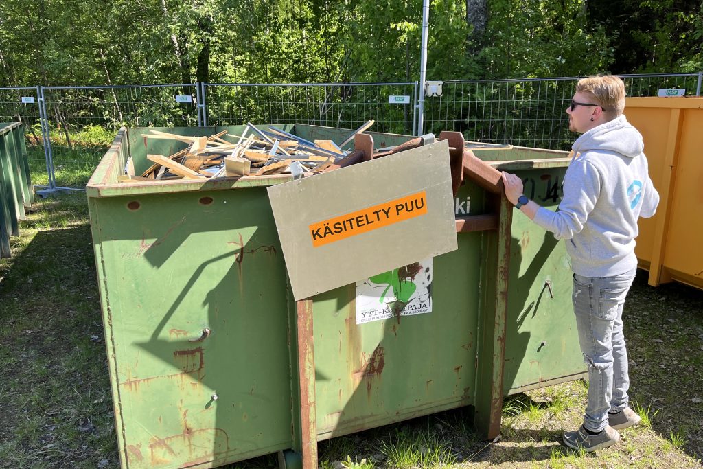 Mies katselee jätelavaa, jossa puumateriaalia.