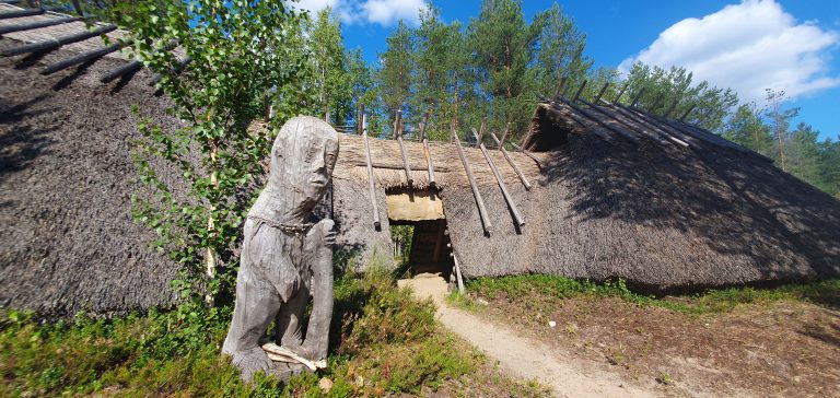 Veistos vanhan luola-asumuksen edessä.