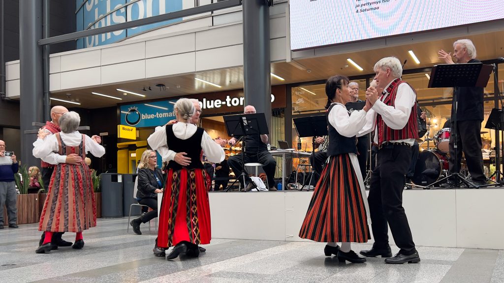 Orkesteri ja kansantanssijoita kauppakeskuksen aulassa.