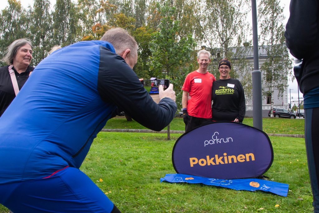 Mies ottaa valokuvaa pariskunnasta kyltin luona.