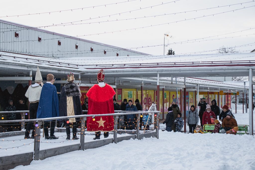 Ihmiset seuraavat tiernapoikaesitystä vanhan ostoskeskuksen pihalla.