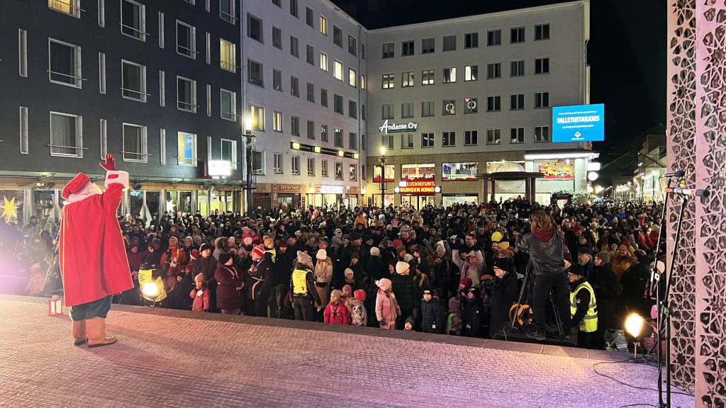 Joulupukki vilkuttaa väkijoukolle lavalta.